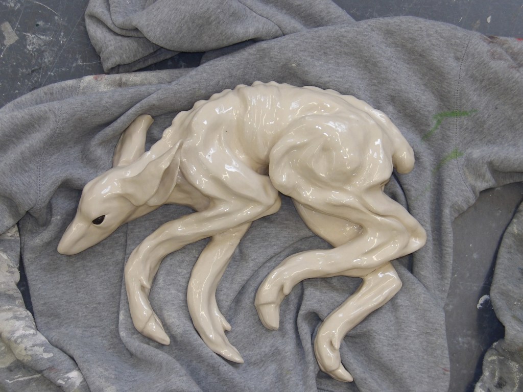 Ceramic deer sculpture lying on a jumper