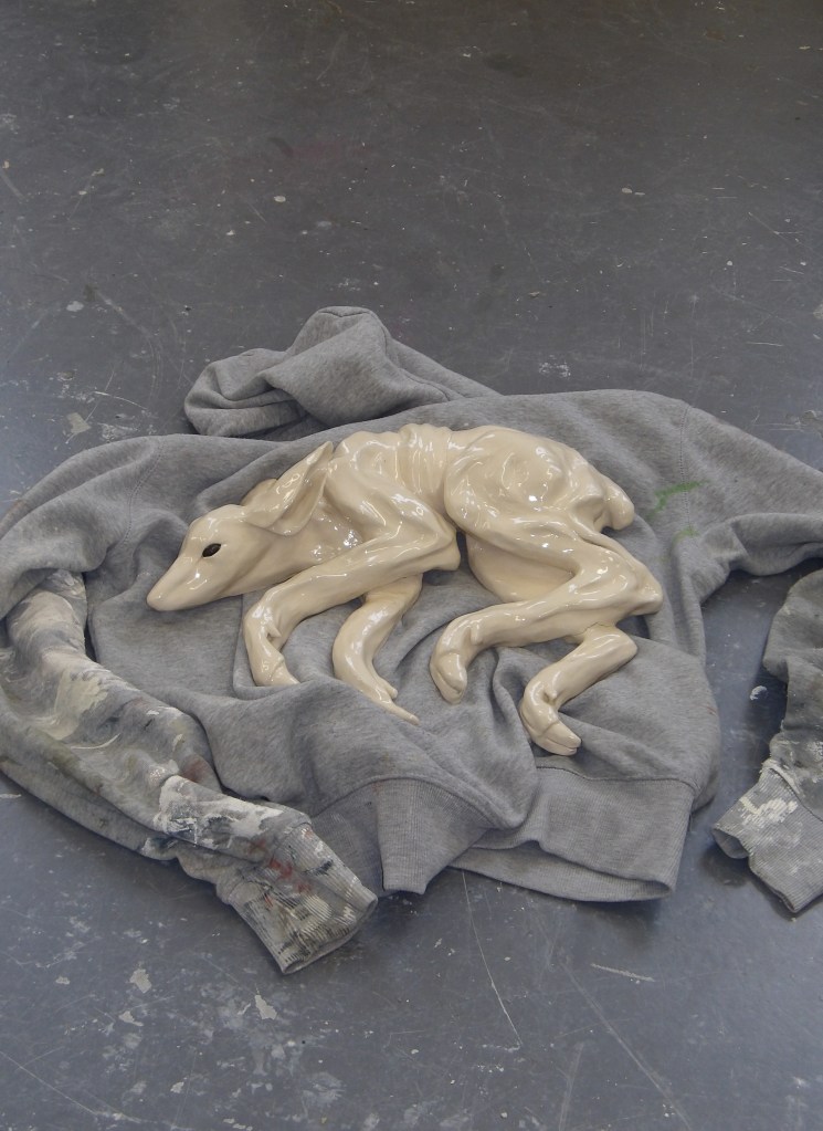 Ceramic deer sculpture lying on a jumper